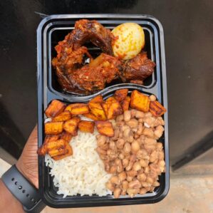 Mama put combo: White rice and beans with plantain, smoked fish, beef and egg