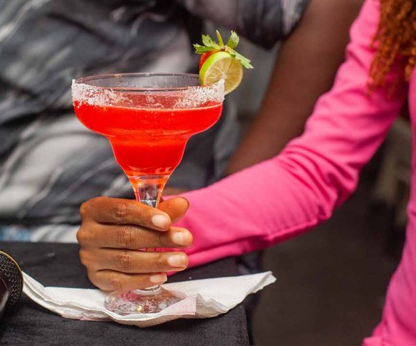 lady holding a pink cocktail
